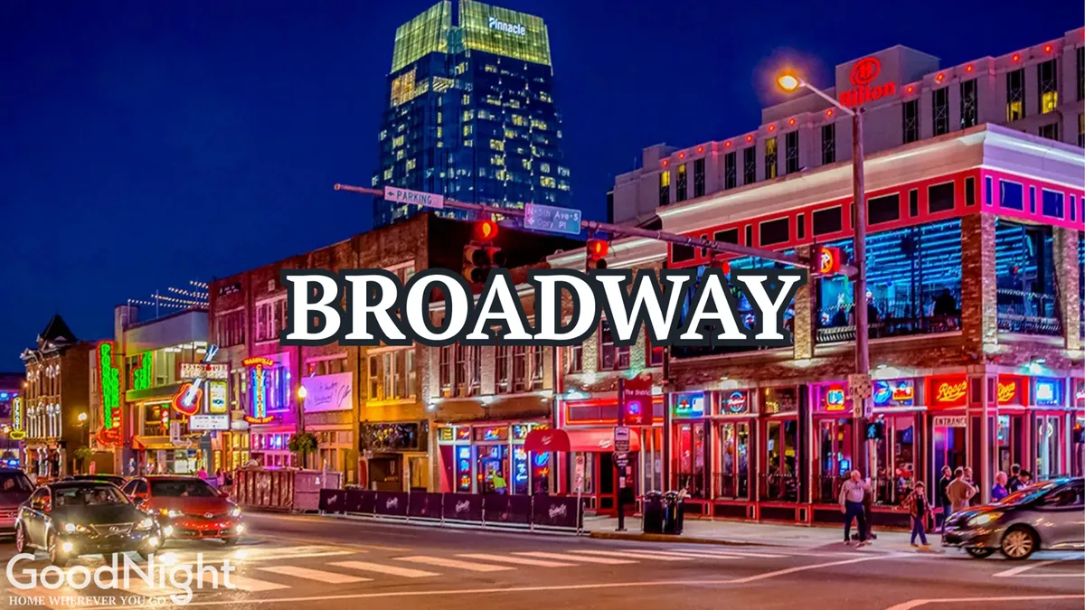 A bustling downtown Nashville street scene at night, with neon signs illuminating historic buildings and crowds of people enjoying a lively atmosphere. The image captures the essence of Music City's nightlife with visible restaurants, live music venues, and honky-tonks lining the street.